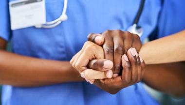 Healthcare worker holding patients hand